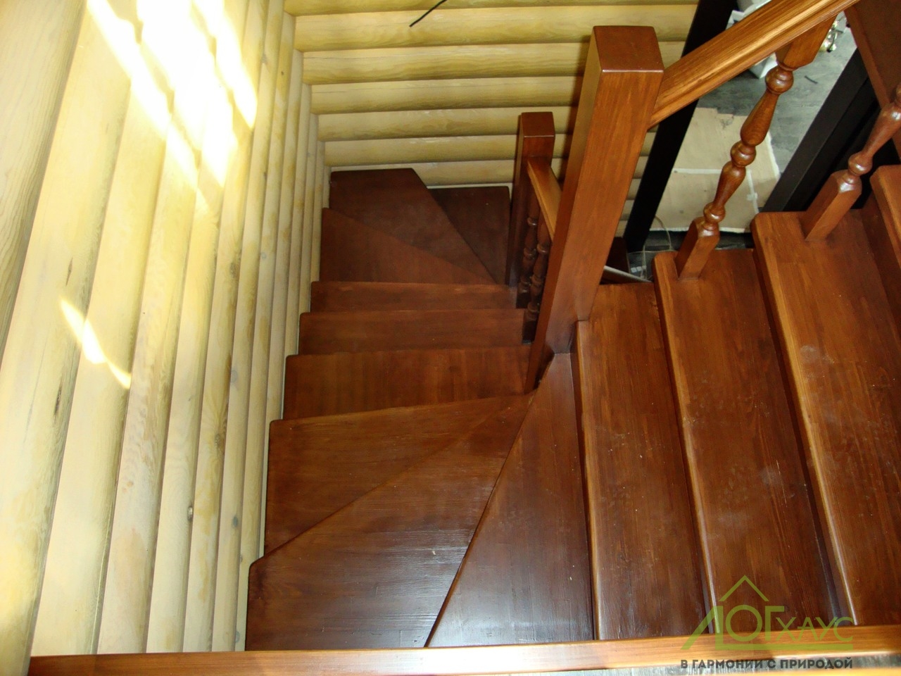 Винтовая деревянная лестница в доме из бревна