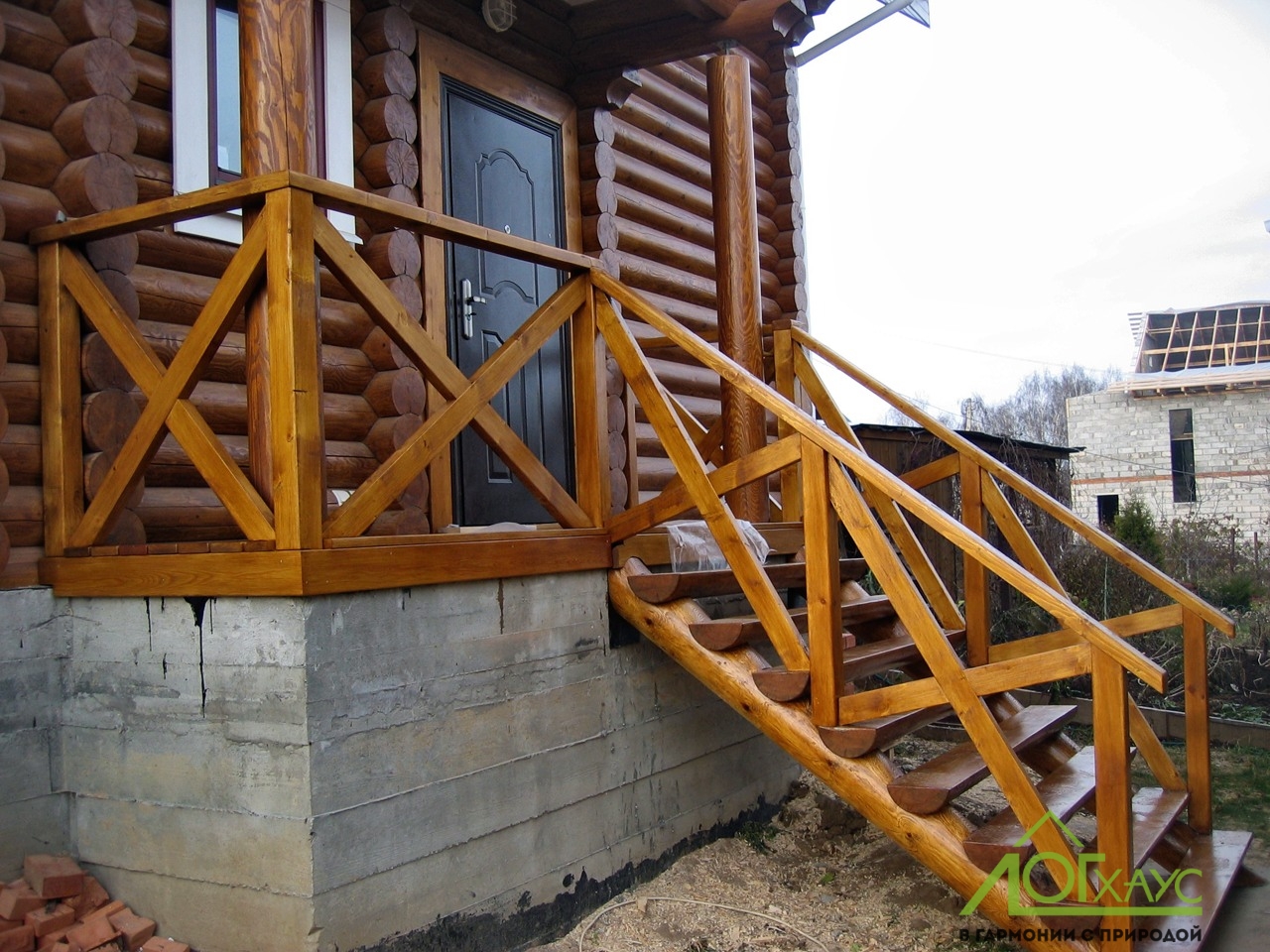 Деревянная лестница и крыльцо дома из оцилиндрованного бревна